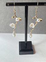 Front view of both earrings on stand showing overall design and pearls