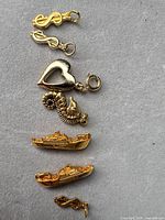 All six gold-tone charms laid out vertically