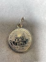Front view of round Hearst Castle San Simeon souvenir pendant with bail attached