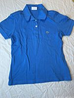 Front view of blue Lacoste kids polo shirt