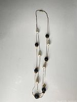 Full view of entire long necklace laid flat