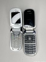 Samsung and LG flip phones open, keypads visible