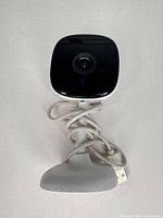 Front view of Merkury MI-CW051 camera on stand with USB cable