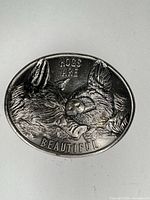 Front of oval pewter buckle showing two hogs and Hogs Are Beautiful text