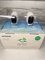 Front view of sealed Netgear Arlo box showing two cameras inside