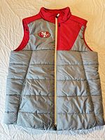 Front view of vest showing gray quilted body, red yoke, white zipper, 49ers logo