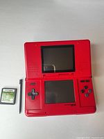 Console open showing both screens, stylus and game cartridge beside