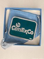 Front view of pewter belt buckle in box with pouch