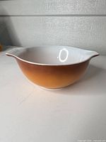 Side view showing orange-to-brown gradient exterior and one handle