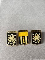 Front view of all three heraldic enamel lapel pins