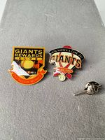 All three Giants lapel pins on grey background