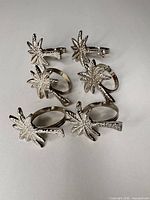 Six stainless steel napkin rings arranged on surface