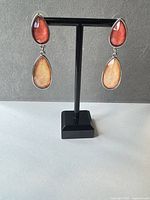 Front view of both earrings on stand showing cabochon colors and silver-tone settings