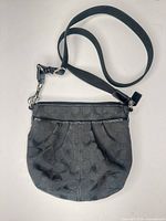 Full view of the small black jacquard canvas crossbody bag with adjustable strap