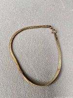 Full view of gold-tone sterling herringbone bracelet showing length and clasp