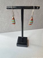 Front view of teardrop inlay earrings on stand