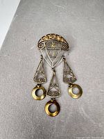 Front view of entire two-tone filigree brooch with dangles