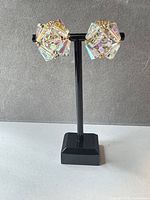 Front view of both clip-on earrings on stand showing crystal clusters