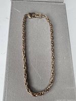 Full view of gold-tone rope chain necklace laid flat