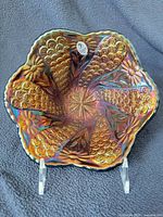 Front view of iridescent ruffled carnival glass bowl on stand