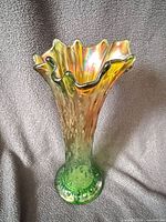 Full view ruffled rim green carnival glass vase front