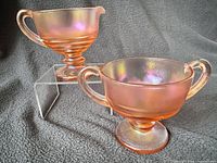 Front view of both iridescent stretch glass pieces showing form and colour