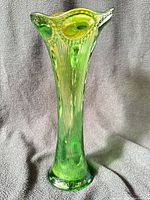 Full view of green carnival glass vase standing upright