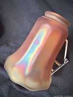 Full view of marigold carnival glass lamp shade showing rainbow iridescence and flared bottom edge