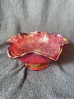 Oblique view showing overall shape, ruffled rim, pedestal base, red/amberina color