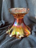 Side view of marigold carnival glass punch bowl base showing ruffled foot and fluted collar