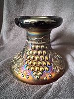 Oblique view of carnival glass punch bowl base showing grape and cable pattern and iridescent amethyst color
