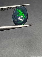 Side view of the opal showing green honeycomb play-of-colour