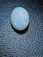 Front view of oval opal showing multicolour play
