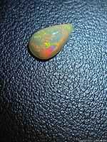 Pear cabochon fire opal on textured background