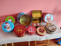 Overview of all eleven Christmas cookie tins arranged on table