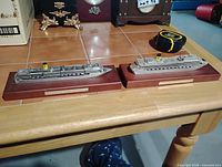 Both pewter cruise ship models side by side on table