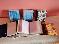 Group of photo albums standing and laying open showing exterior patterns and interior photo sleeves