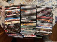 Three tall stacks of DVD cases on table, spines visible