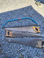 Lot overview showing three hand saws and one bow saw on gravel