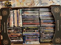 Box containing rows of DVD and Blu-ray cases, titles visible