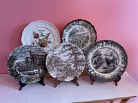 Front view of all five decorative plates on stands