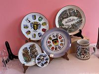 Group view of five plates and mug on stands