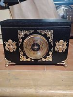 Front view showing barometer dial and decorative appliqués