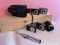 Group shot showing two Sony camcorders, four digital cameras and mini tripod