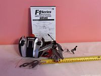 Helicopter, remote controller, USB cable, instruction manual with tape measure for scale
