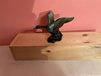 Front view of green glazed ceramic Canadian goose figurine on wood block