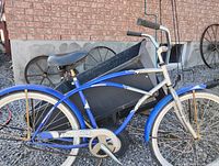 Full left side view of blue and white Vagabond ladies cruiser bicycle leaning against cart