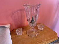 Front view of large hurricane candle holder flanked by two square votive holders