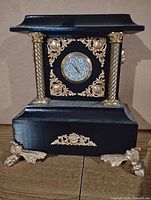 Front view showing overall design, dial, gold accents, and feet