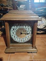 Front view of wooden mantel clock showing dial and case